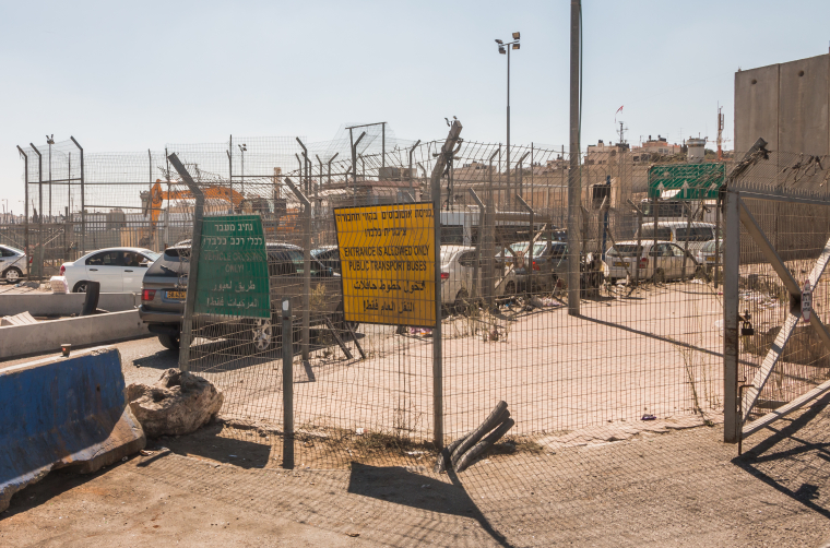 Mříže, ploty, ostnaté dráty a kolony aut na checkpointu Kalandia