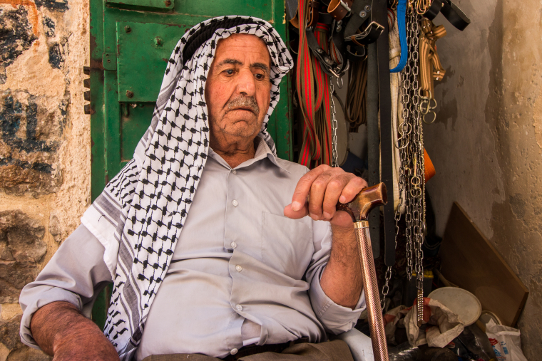 Palestinec odpočívá před svým krámkem v uličkách Starého města