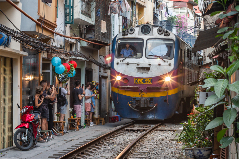 Vlaky ve Vietnamu – Úzkými uličkami Hanoje projíždí vlak několikrát denně. Místní musí sbalit veškeré věci a ustoupit z cesty mohutnému kolosu.